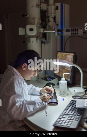 France, Eure, Grand Bourgtheroulde, environmental laboratory, analyst positioning microscopy grids on a Analytical Transmission Electron Microscope (ATEM) sample holder Stock Photo