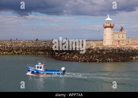 Ireland, Fingal County, northern suburbs of Dublin, Howth, the port, departure of a fishing boat passing in front of the lighthouse of the city Stock Photo