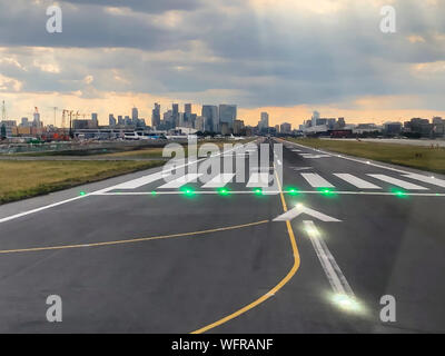 London, United Kingdom - 12 July 2019: London's financial district of Canary Wharf is visible right in the extension of Runway 27 of London City Airport (LCY). Stock Photo