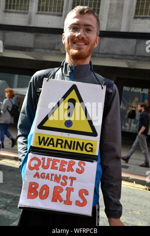 A man carries a 'Queers Against Boris' placard at the Extinction Rebellion event which blocked Deansgate in central Manchester, uk, on 31st August, 2019 on the second day of a four day protest. The protesters are demanding that the Government tells the truth about the climate emergency, takes action now, and is led by a citizens' assembly on climate change. Stock Photo