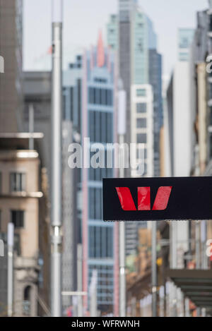 A Westpac Bank (WBC bank) logo sign outside a city branch in Sydney Australia with high rise city towers in the background Stock Photo