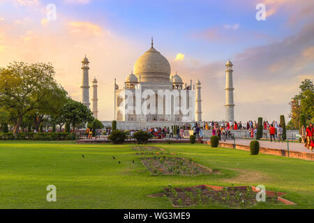 Taj Mahal -Historic white marble mausoleum at sunset with view of tourists visiting the monument at Agra, India Stock Photo