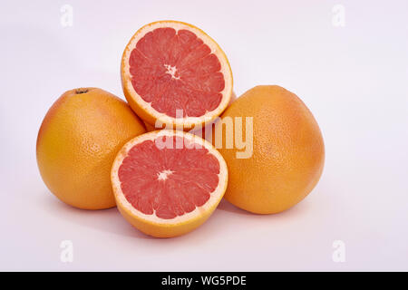 Pink grapefruits - whole and cut - on a white background Stock Photo