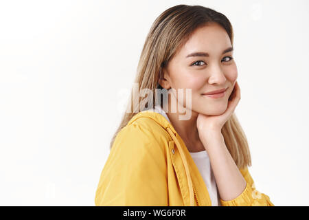 Close-up tender stylish cheerful feminine happy lucky asian blond girl turn camera half-turned look smiling tender touch clean skin no-acne satisfied Stock Photo