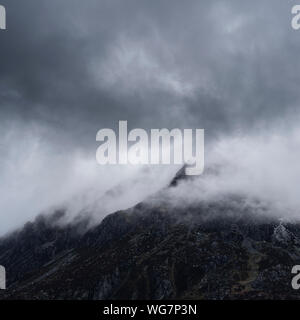 Stunning detail landscape images of snowcapped Pen Yr Ole Wen mountain in Snowdonia during dramatic Winter storm Stock Photo