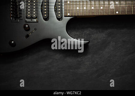 Black electric guitar on black cement floor. Top view and copy space for text. Concept of rock music. Stock Photo