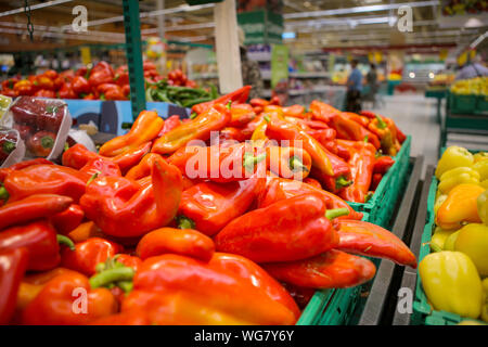 Red and yellow sweet peppers on the fruits and vegetables aisle in a store Stock Photo