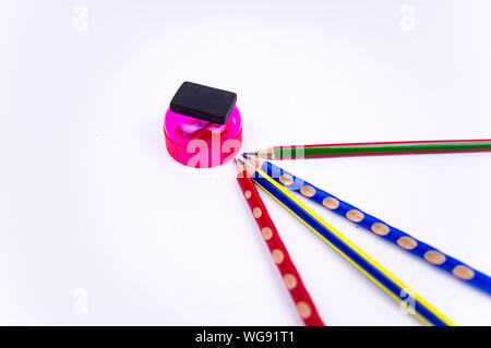 colored pencils with eraser and sharpener on a white background, there is free space to fill the text Stock Photo