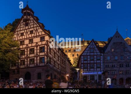 Young people at dusk below the Kaiserburg during the Bardentreffen, Tiergartnertor, Nuremberg, Middle Franconia, Bavaria, Germany Stock Photo