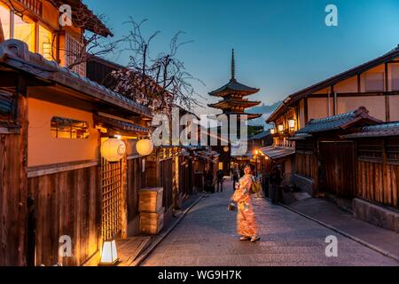 Woman in Kimono posing in an alley, Yasaka dori historical alleyway in the old town with traditional Japanese houses, back five-storey Yasaka pagoda Stock Photo