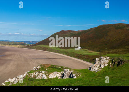 The extensive sandy beach in Rhossili Bay is overlooked by the ridge of Rhossili Down on the Gower peninsula, South Wales, UK Stock Photo