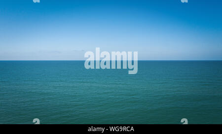 Seascape with sea horizon and almost clear deep blue sky Background Stock Photo