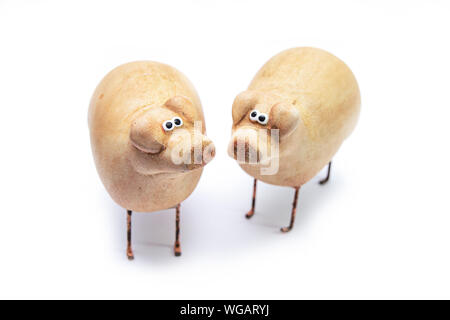 Small clay figurines of pigs isolated on a white background. A symbol of prosperity and prosperity. Stock Photo