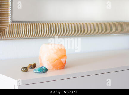 himalayan pink salt lamp on white table Stock Photo