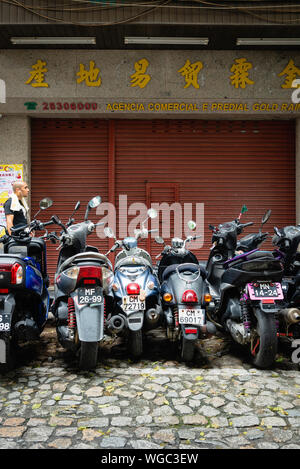 Motorcycles parked on a street in Macau Stock Photo