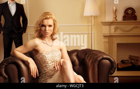 Luxury woman and man behind in rich interior Stock Photo