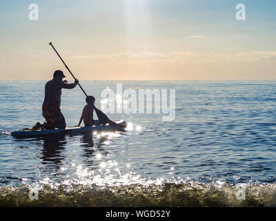 Sup surfing training, father and sun swim in the open sea on SAP surfing Stock Photo