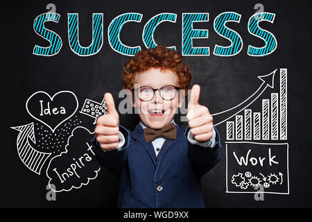 Handsome little boy showing thumbs up. Business idea, education, start-up and success concept Stock Photo
