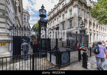 Armed police guarding security gate at the entrance to Downing Street, City of Westminster, London, England, UK. Stock Photo