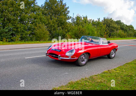 Classic Red Convertible Car Traveling In The Countryside At Sunset