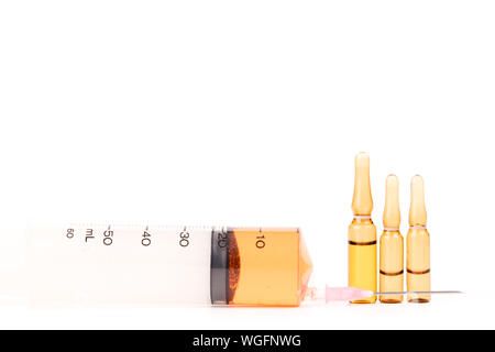 Close-up Of Syringe And Vials Over White Background