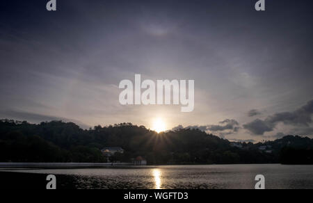 Amazing sun halo above the lake at the center of Kandy city, Sri Lanka. And it’s natural phenomenon. Stock Photo