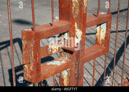 Close-up of rusty metal gate latch on a set of industrial gates Stock Photo