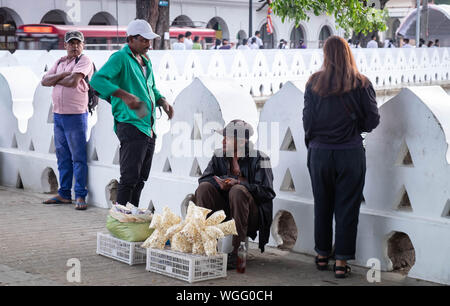 KANDY/ SRI LANKA, AUGUST 04-2019: Unspecific people around the lake. in everyday life. Someone who sell somethig for his life. Stock Photo