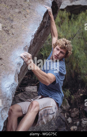 Young Man Climbing On Rock