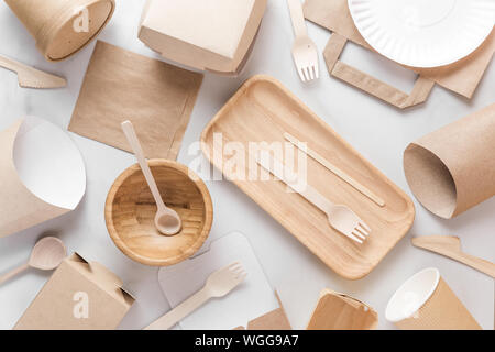 Eco friendly dishes. Disposable paper cups, dishes, fast food containers, wooden bowl and bamboo cutlery. flat lay. top view. recycling concept Stock Photo