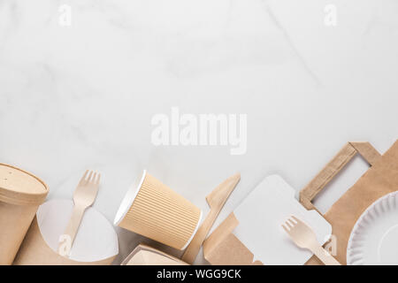 Eco friendly disposable tableware. Paper cups, dishes, fast food containers and bamboo wooden cutlery. flat lay. top view with copy space. recycling c Stock Photo