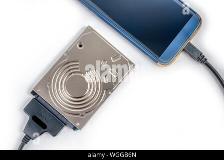 hdd 2.5 hard drive disk connected to smartphone via sata usb cable closeup overhead view Stock Photo