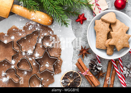 Christmas gingerbread cookies with fir tree branches, gift boxes and decorations on gray concrete background. top view. flat lay Stock Photo