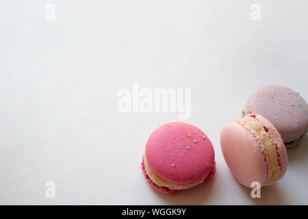 Three sweet macaron cakes or French macaroons isolated on white background close up with a copy space Stock Photo