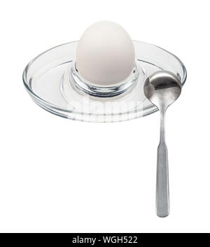 whole boiled white egg and spoon in glass egg cup isolated on white background Stock Photo
