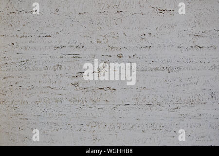 Rough white natural stone travertine with small random cavities. Limestone building material. Stock Photo