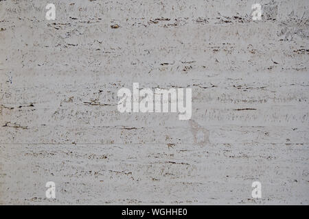 Rough white natural stone travertine with small random cavities. Limestone building material. Stock Photo