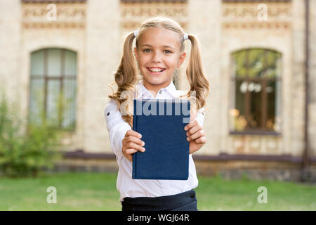 Knowledge day. Ready for lessons. Secondary school student. Cute smiling small child hold book. Adorable little girl school student. Study language. School education concept. Cute little bookworm. Stock Photo