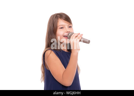 Little girl posing with a microphone for singing on white background. Stock Photo