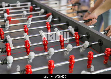 Young people playing foosball while resting indoors Stock Photo