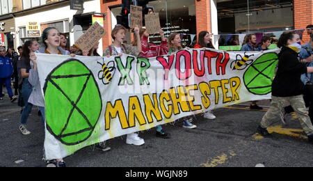 A group from Extinction Rebellion Youth arrive with their banner on Deansgate as Northern Rebellion protesters, part of the global movement Extinction Rebellion, blocked Deansgate in central Manchester, uk, on 1st September, 2019 on the third day of a four day protest. The protesters are demanding that the Government tells the truth about the climate emergency, takes action now, and is led by a citizens' assembly on climate change. Stock Photo