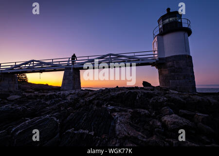 Dawn breaks over the Marshall Point Lighthouse near Port Clyde, Maine. The current lighthouse was built in 1832 on a rocky point of land near the mouth of Port Clyde Harbor and was featured in the major motion picture Forrest Gump. Stock Photo