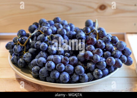 Red globe realistic grape bunch on plate for healthy dessert image Stock Photo