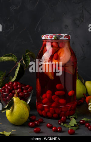 Dogwood compote with pears in jar on a dark background, vertical orientation Stock Photo