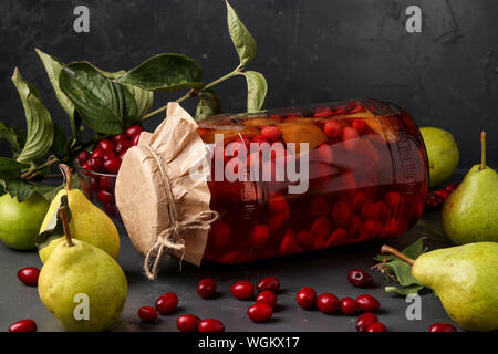 Dogwood compote with pears in jar on a dark background, horizontal orientation Stock Photo