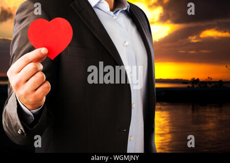 Businessman in a classic suit with an red heart on a dark night background Stock Photo