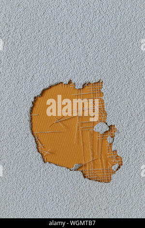 hole in the plaster wall covered by yellow surface Stock Photo