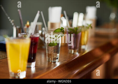 Row of colorful drinks on bar stand, refreshing cocktails and mojito glass, copy space Stock Photo