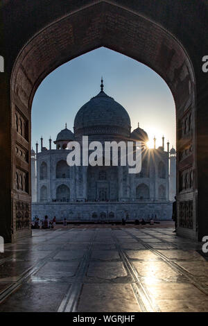 Sunburst just over the Taj Mahal viewed through the arch of the Mosque. Stock Photo