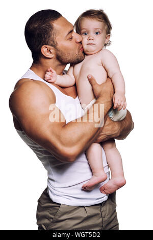 Father Kissing Cute Daughter While Standing Against White Background